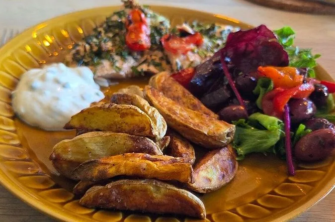 Ein Teller mit Bratkartoffeln, Roter Bete, Salat und einem weißen Dip